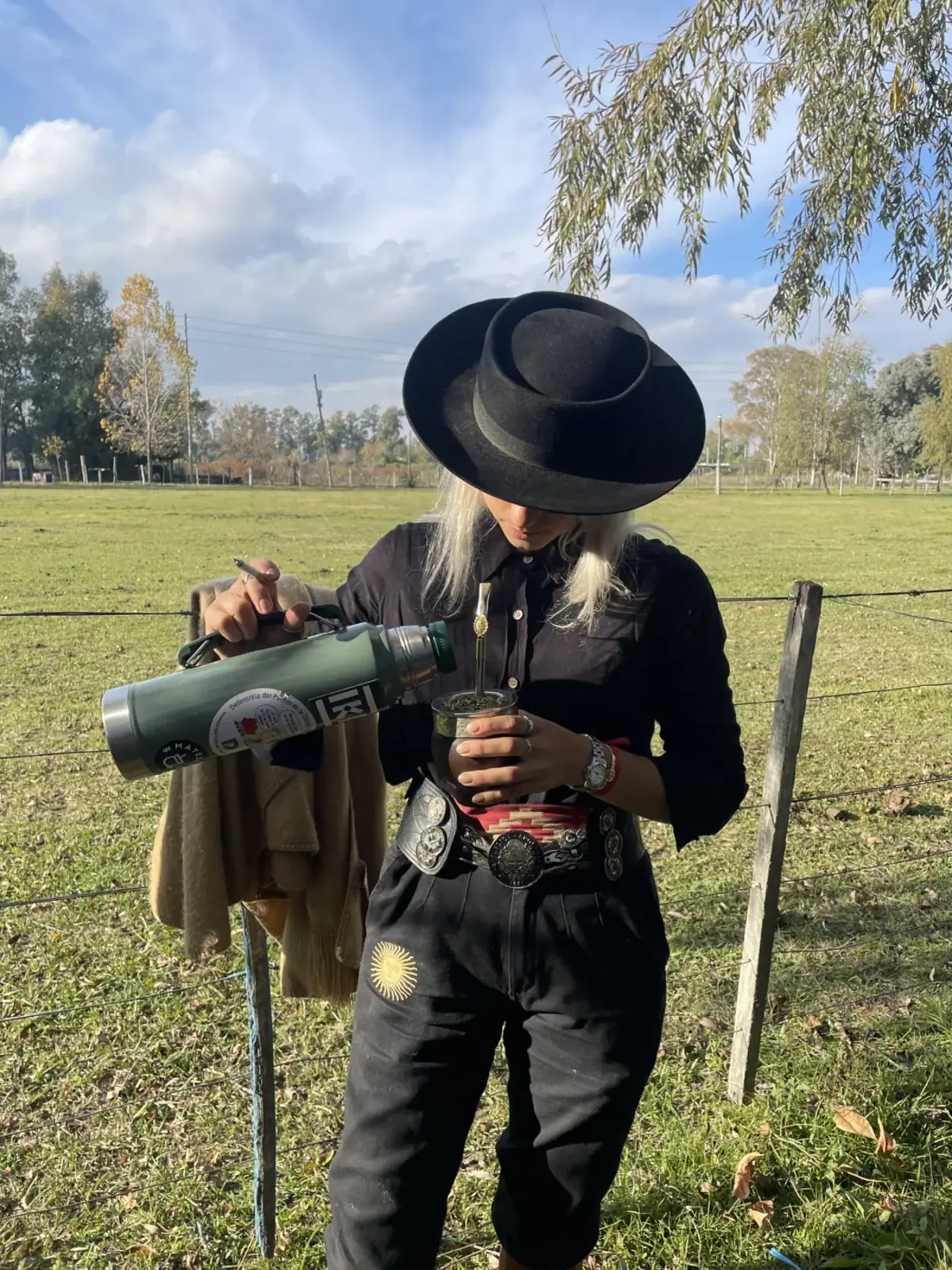 Cebando mate en el campo con indumentaria Autóctona